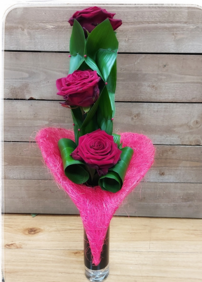 Three Kisses - Three Naomie roses built within an Aspdistra framework, heart collar and black tubular vase.